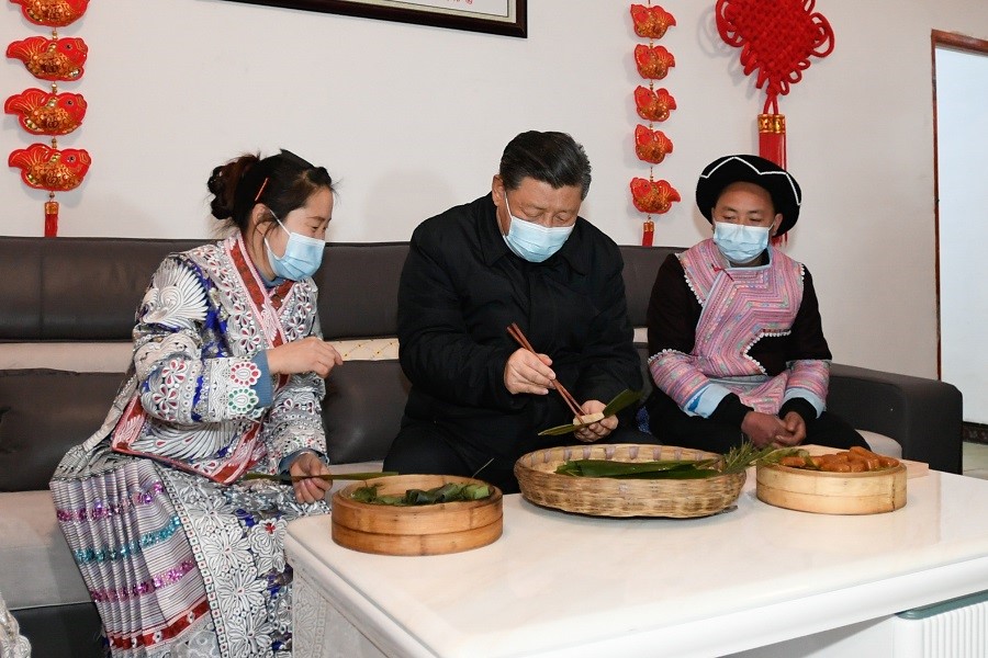 2021年2月3日下午，習(xí)近平在貴州畢節(jié)市黔西縣新仁苗族鄉(xiāng)化屋村苗族村民趙玉學(xué)家，同一家人邊聊家常邊制作當(dāng)?shù)貍鹘y(tǒng)節(jié)日食品黃粑。新華社記者 李學(xué)仁 攝