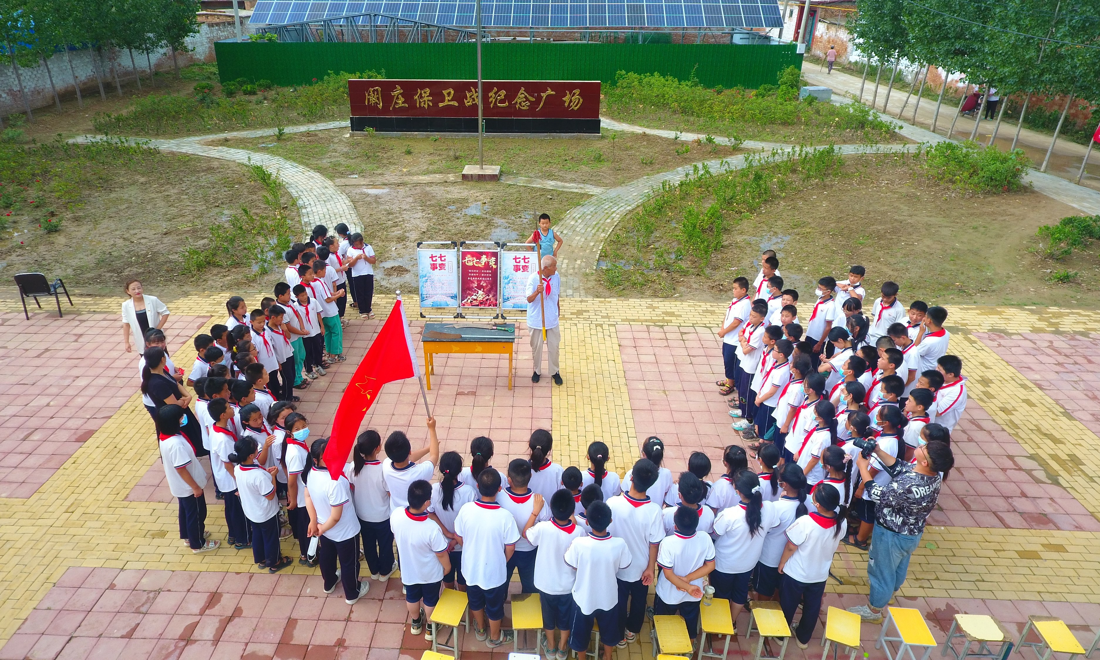 2022年7月6日，山東省聊城市，在茌平區(qū)菜屯鎮(zhèn)闞莊村的闞莊保衛(wèi)戰(zhàn)紀(jì)念廣場(chǎng)，闞莊保衛(wèi)戰(zhàn)親歷者王光木老人，為小學(xué)生們講述抗戰(zhàn)故事，展示大刀、長(zhǎng)矛。