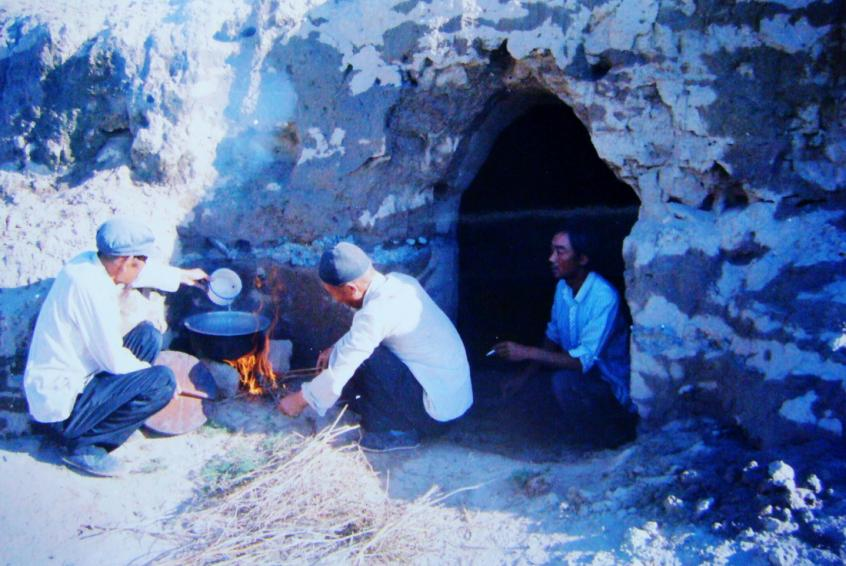 1983年，“六老漢”一代治沙人在“地窩子”生活做飯。新華社發(fā)（八步沙林場供圖）